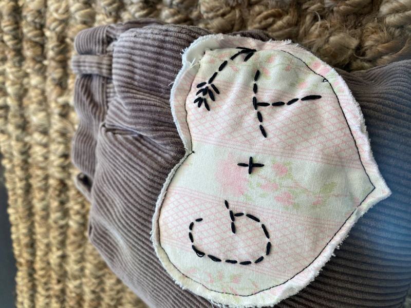 Corduroy pillow with hand-stitched initials made from Pap's pants and Grandma's nightgown