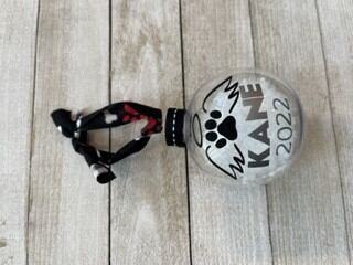 Glass holiday ornament with pet keepsake filling and name tag